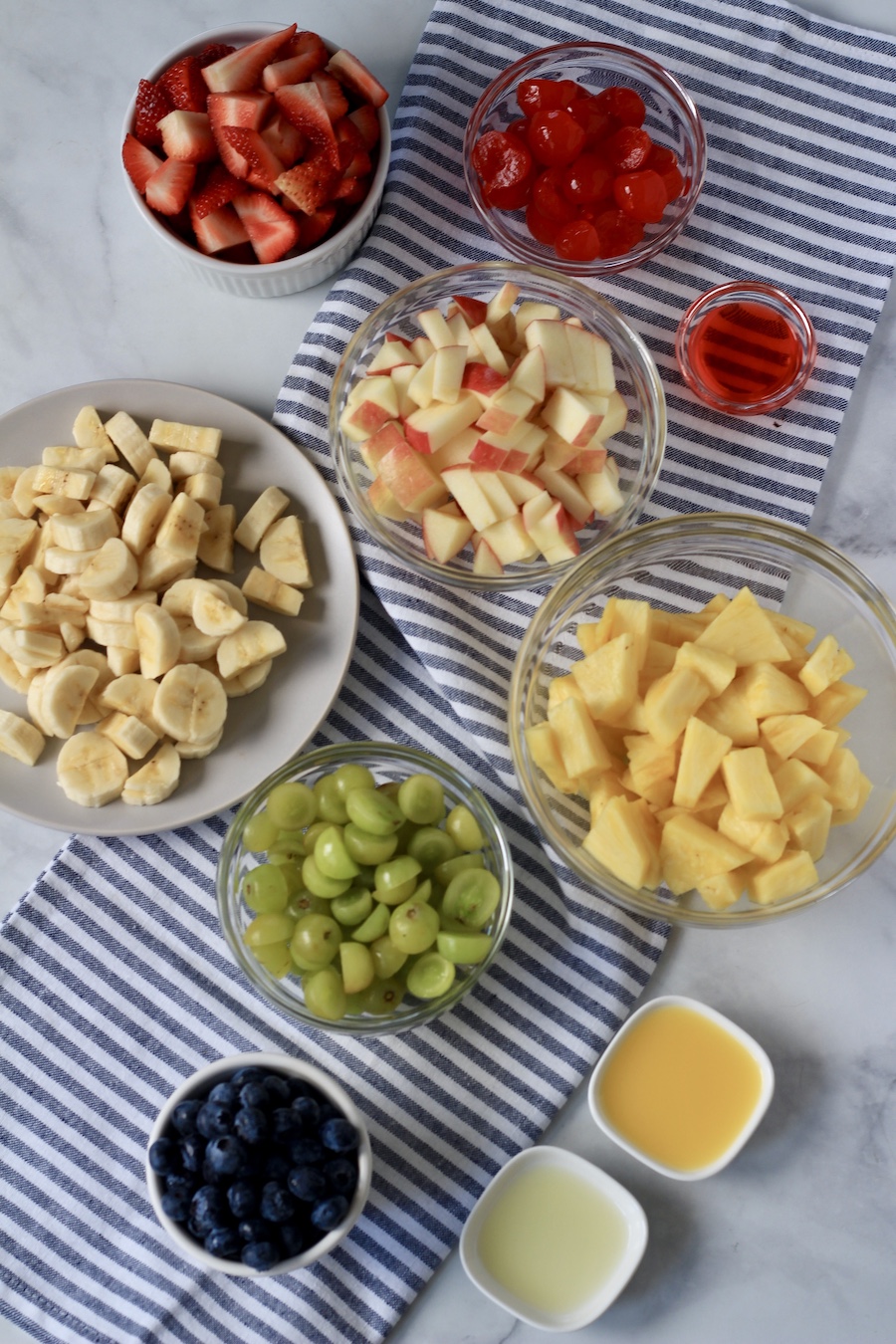 Different fruits in small bowls for fruit salad.