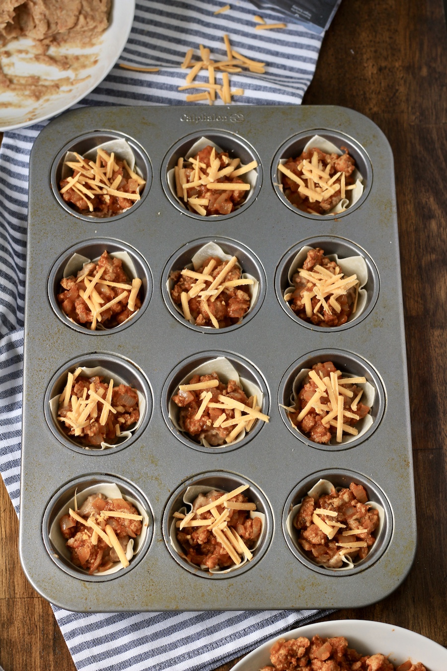 Taco cups in a muffin tin before baking.