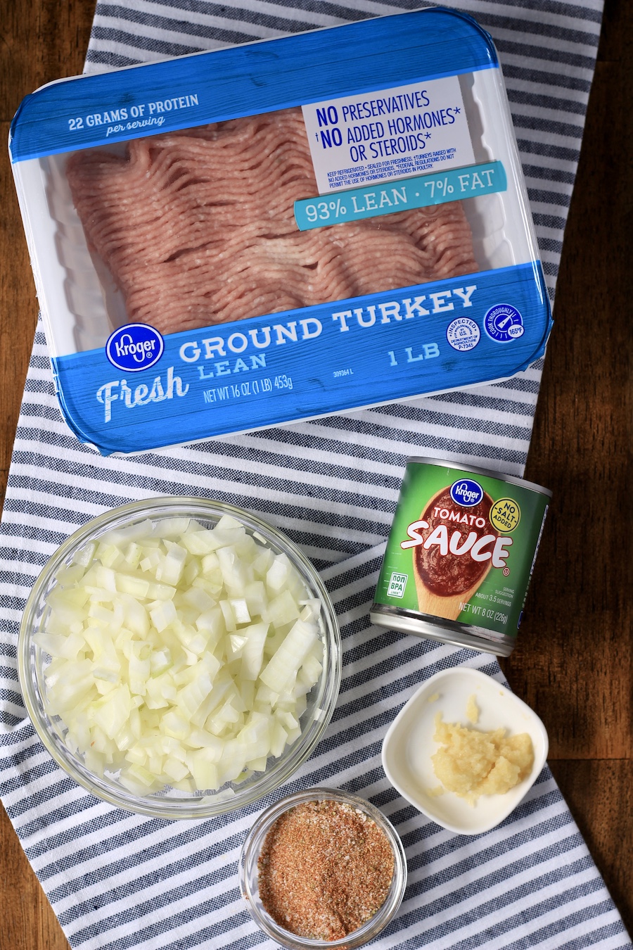 Ingredients for taco meat on a white and blue dish towel.
