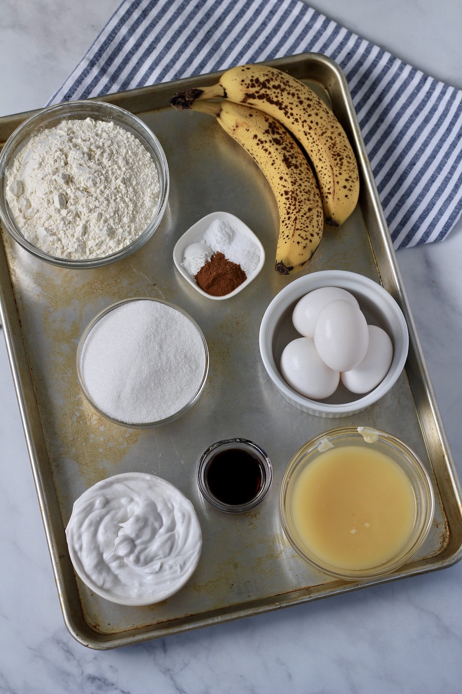 A silver tray with ingredients for banana snack cake.
