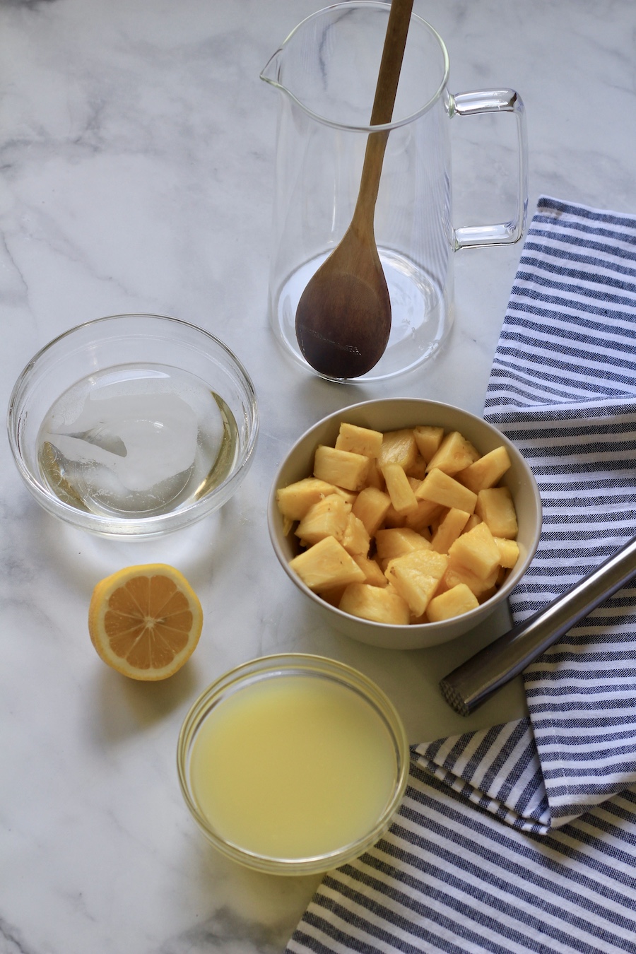 Ingredients for pineapple lemonade in bowls on a counter.