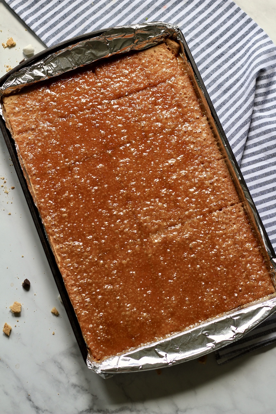 Lined baking sheet with foil topped with graham crackers and toffee after baking.