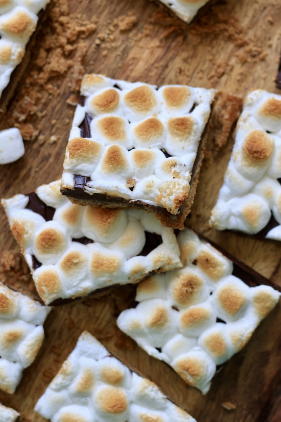 S'mores toffee cut into pieces on a wooden cutting board.