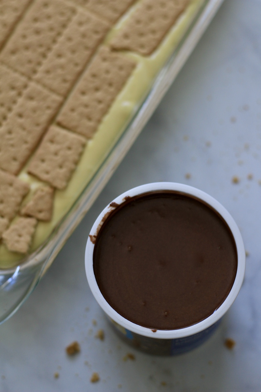 The melted chocolate frosting in a tub next to the dessert pan.