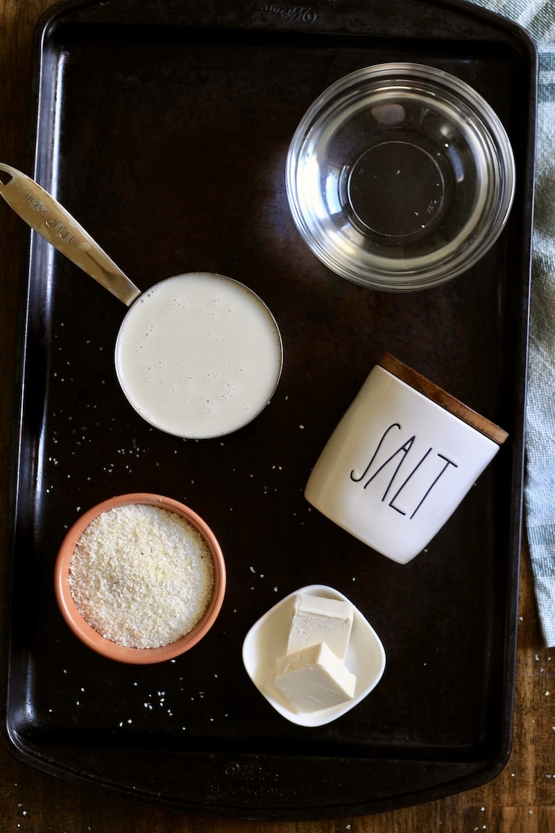 A rimmed baking sheet with the ingredients for creamy grits.