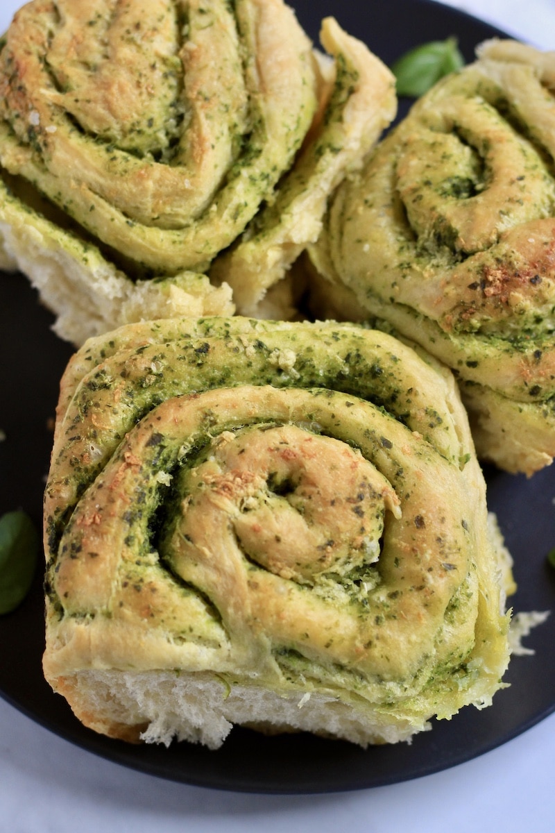 Top down photo with three pesto rolls on a blue plate.