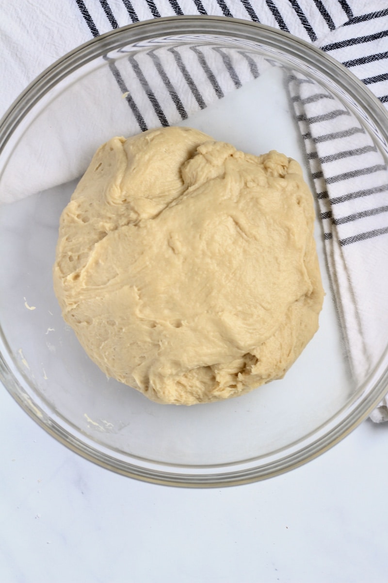 A glass bowl with bread dough before rising.