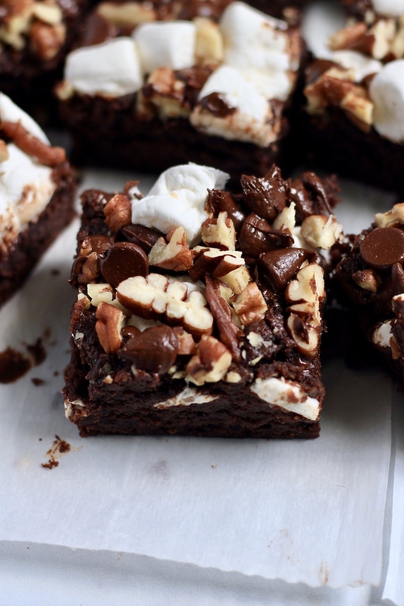 A close up of a vegan rocky road brownie on parchment paper.