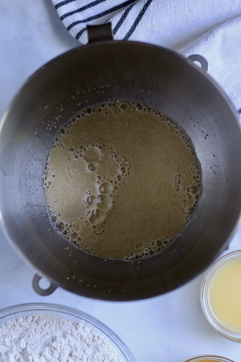 A silver mixing bowl with yeast activating.