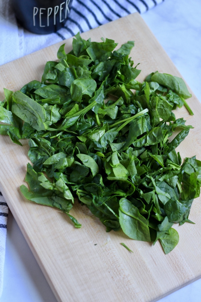 Chopped spinach on a cutting board.