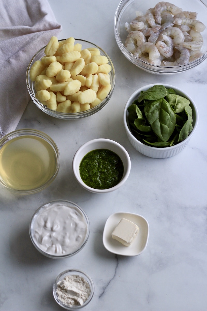Ingredients for creamy pesto gnocchi with shrimp on a counter.