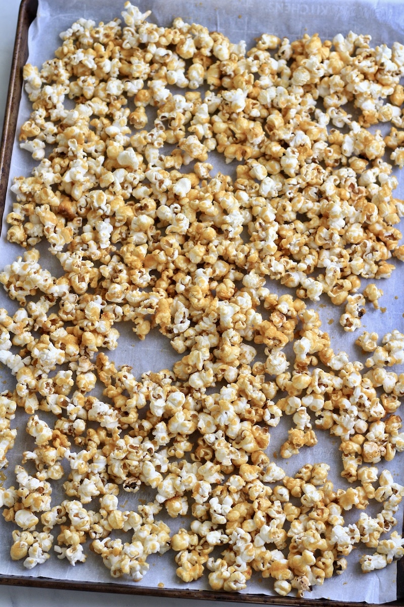 A parchment paper lined baking sheet with caramel corn after baking.