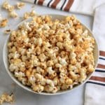 A white bowl with fresh vegan caramel corn.