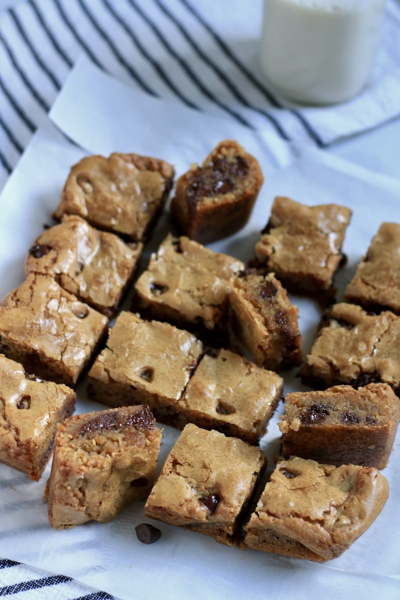An arrangement of blondies top down and on their side with a jar of oat milk behind them.