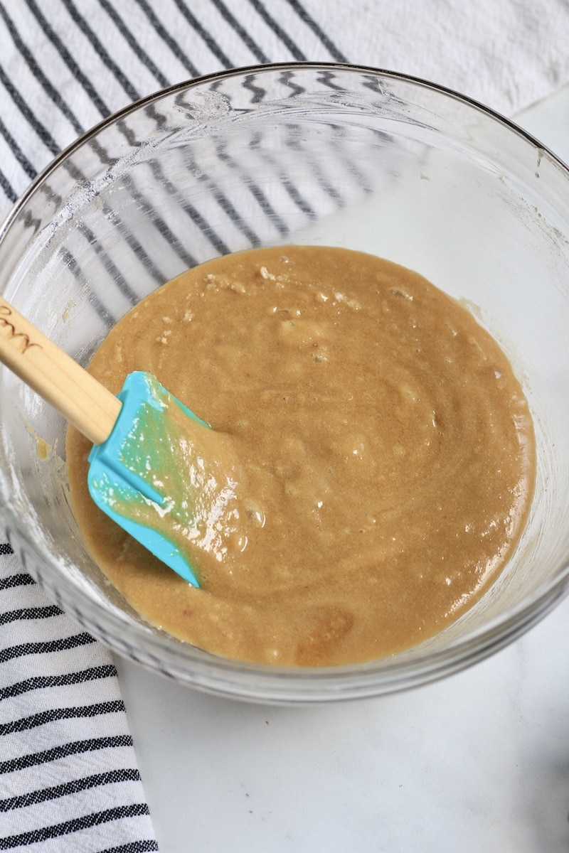 A spatula on the left side of the bowl with blondie batter.