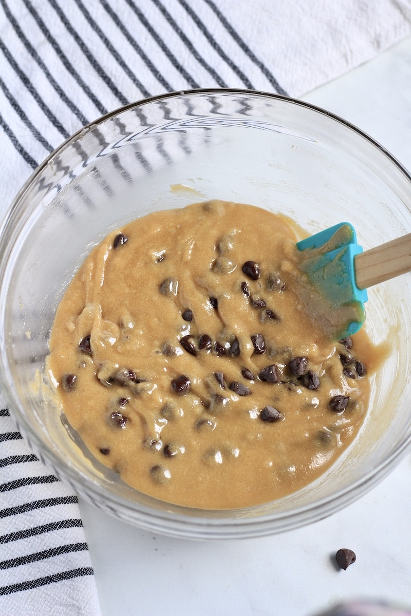 Chocolate chip blondie batter with a rubber spatula after mixing the chocolate chips in.