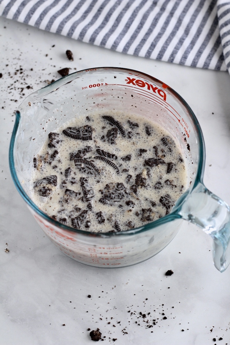Cookies and cream popsicle mixture in a liquid measuring cup.