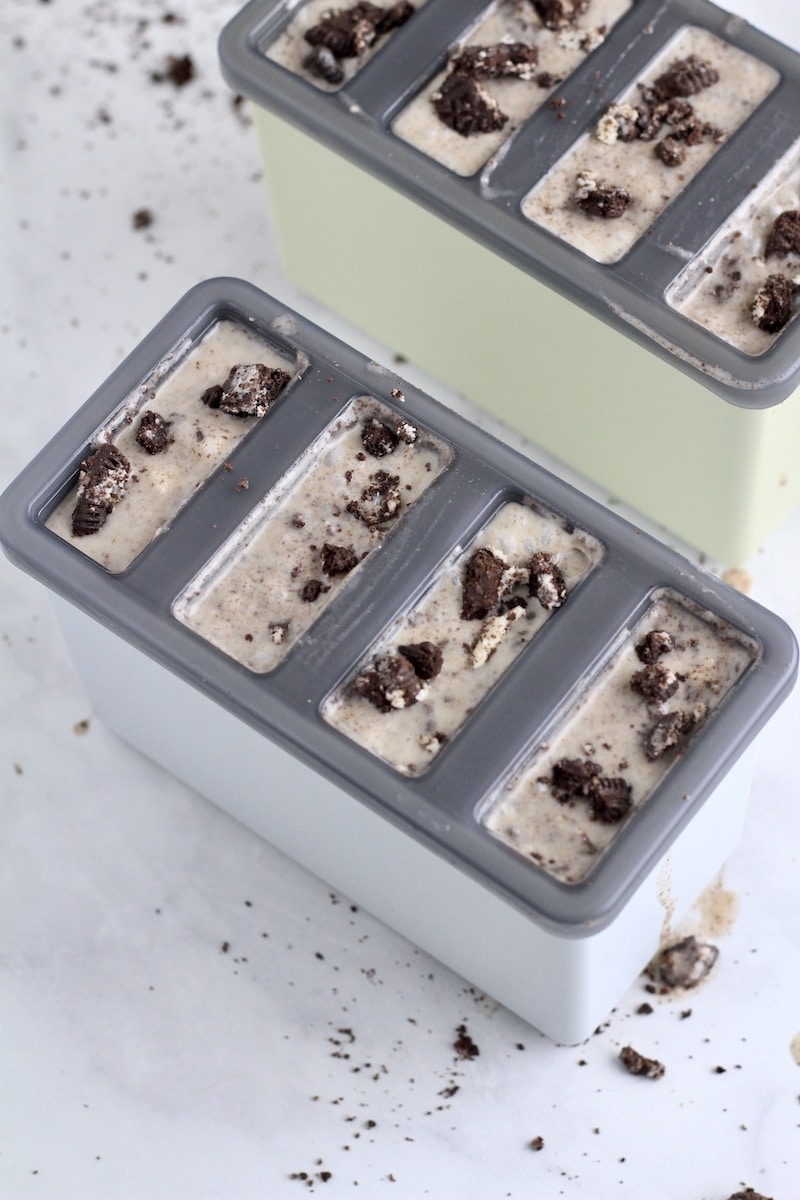 Cookie crumbs sprinkled on top of the cookies and cream popsicle molds.