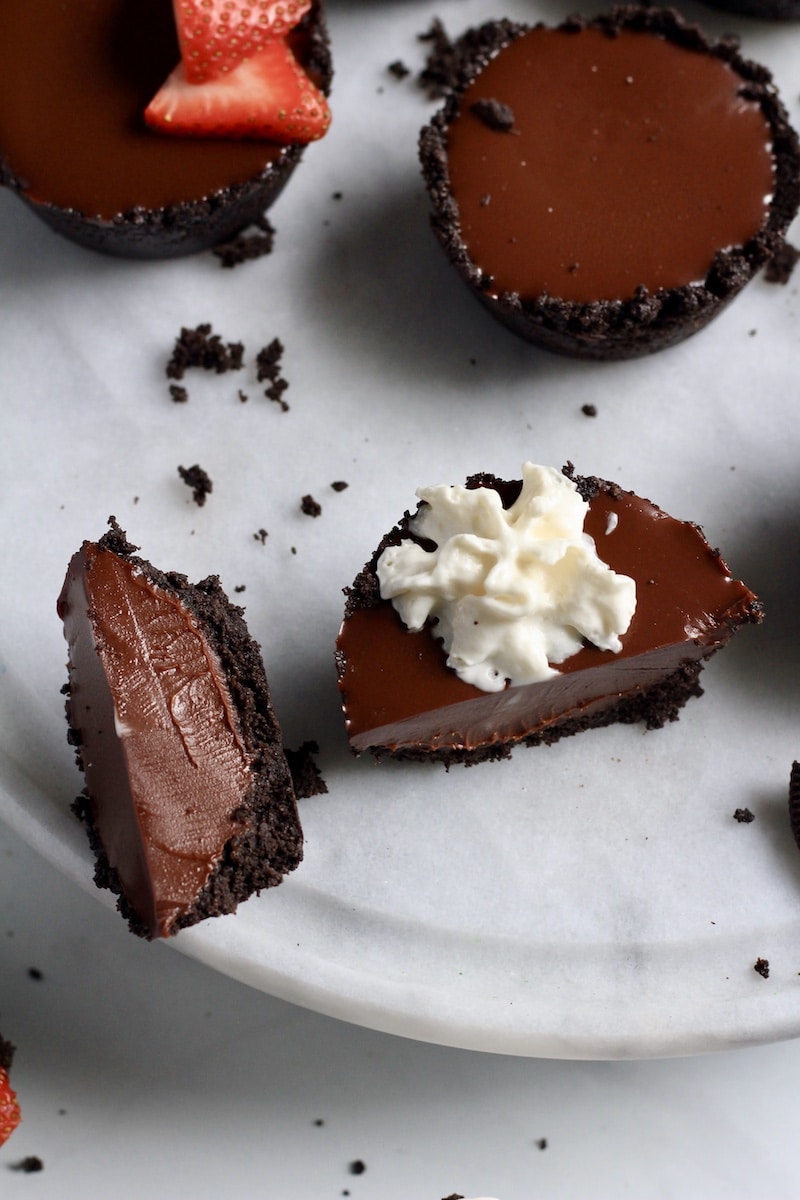 A no-bake mini chocolate tart sliced in half with one half showing the creamy chocolate filling.