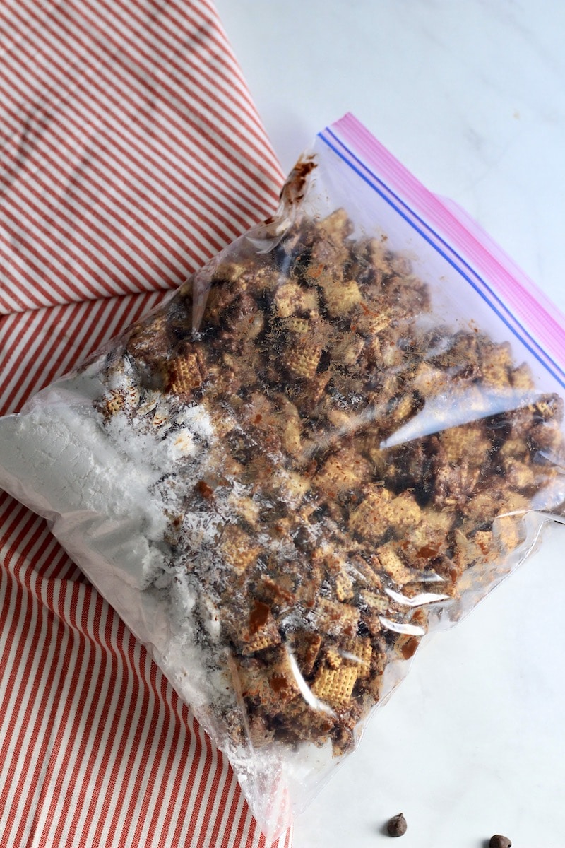 A gallon ziplock with cookie butter coated Chex and powdered sugar before shaking.