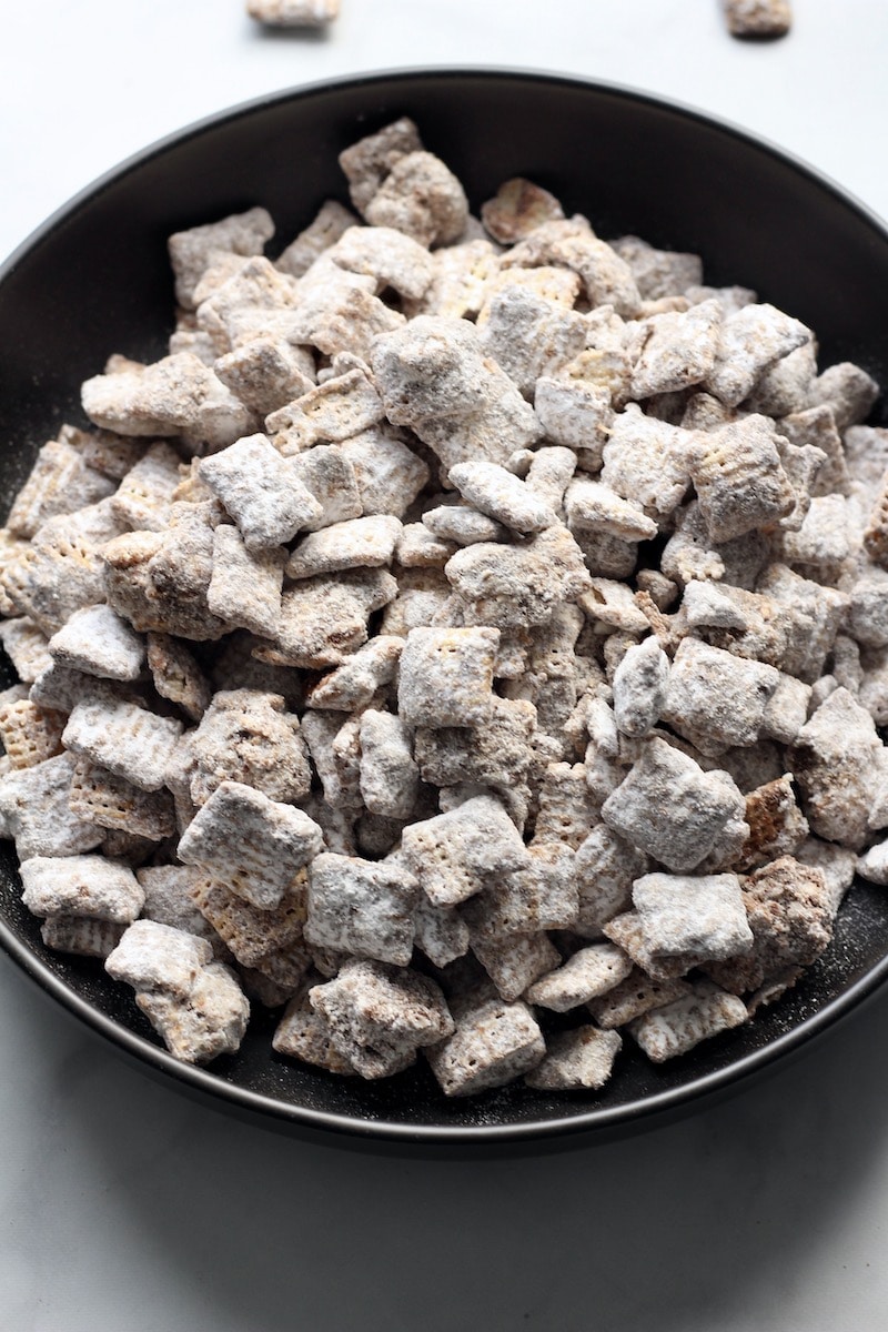 A black bowl filled with cookie butter muddy buddies.
