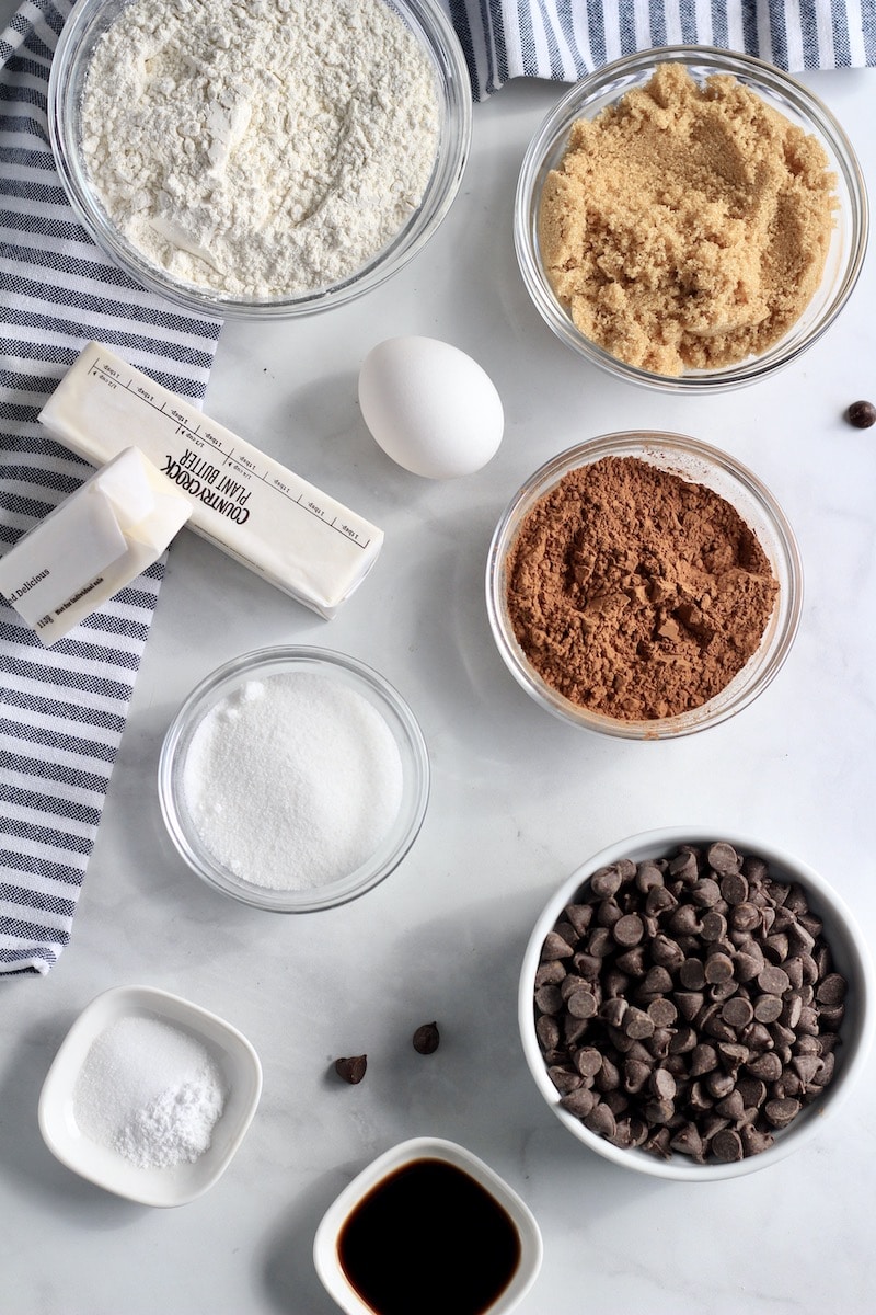 Ingredients on a counter for double chocolate chip cookies measured into individual bowls.