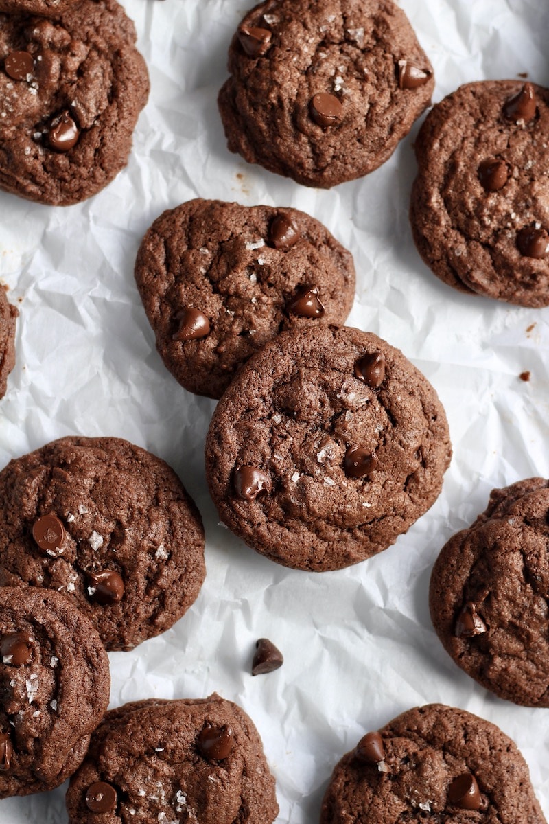 Double chocolate chip cookies scattered on parchment paper.