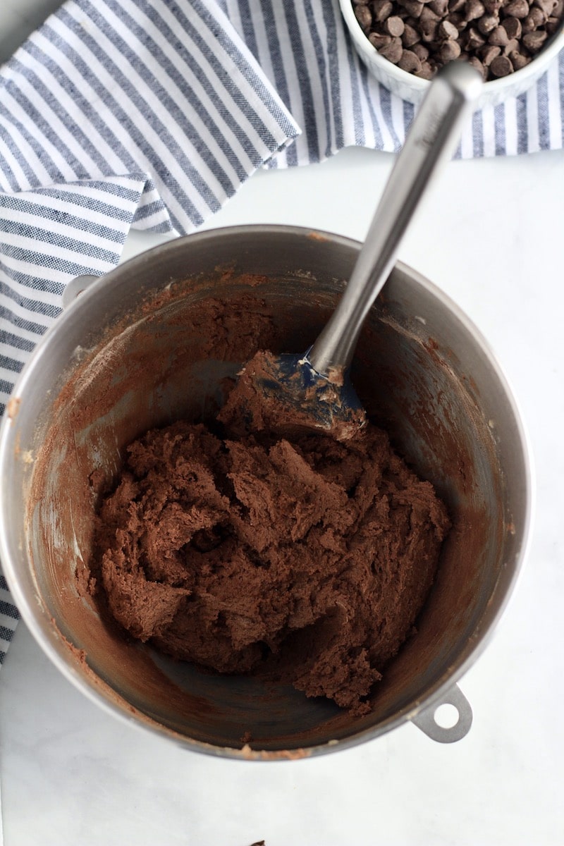 A mixing bowl with a spatula and the chocolate cookie dough.