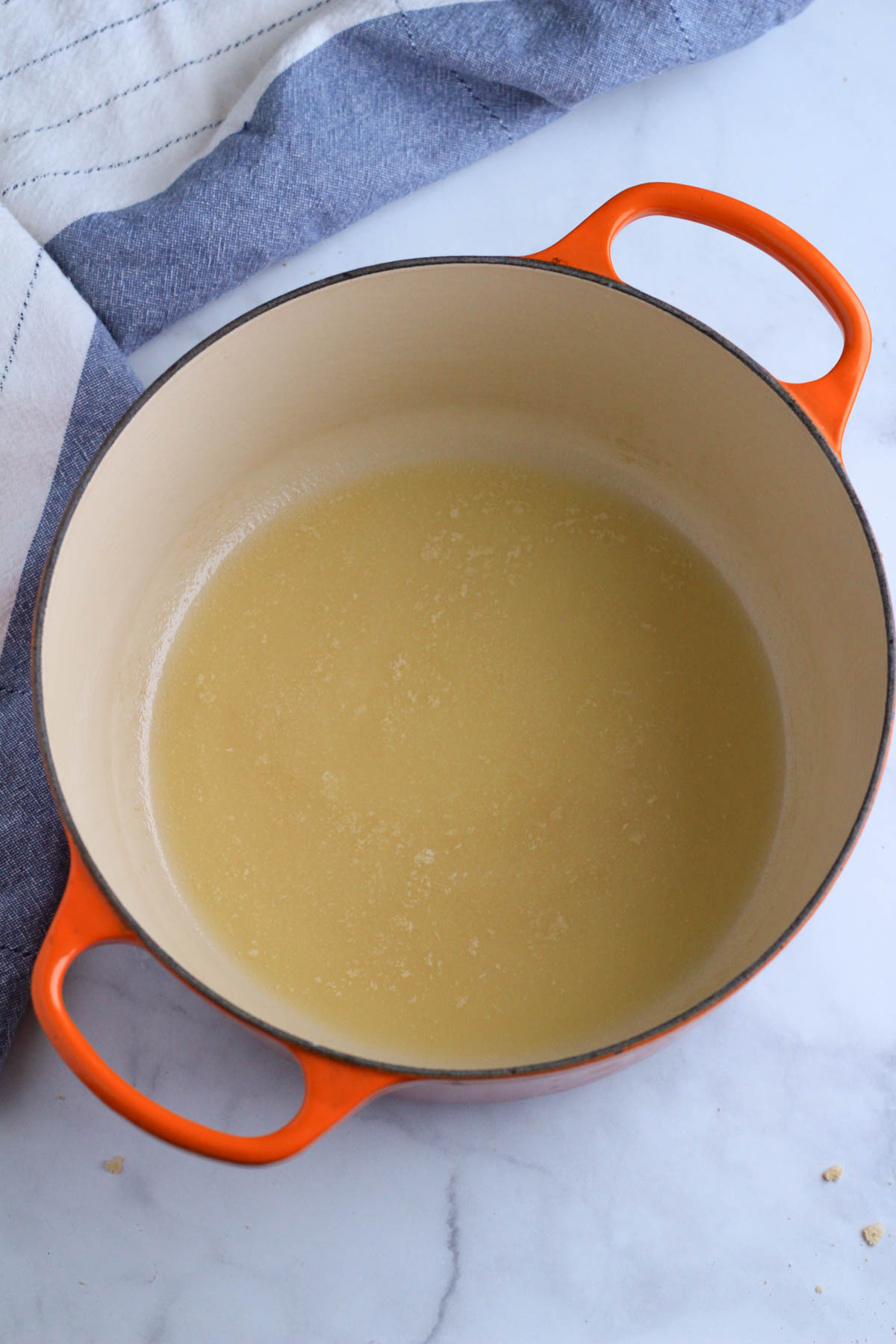 A large orange pot with melted plant-based butter.