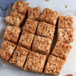 A square of cookie butter rice krispie treats on parchment paper.