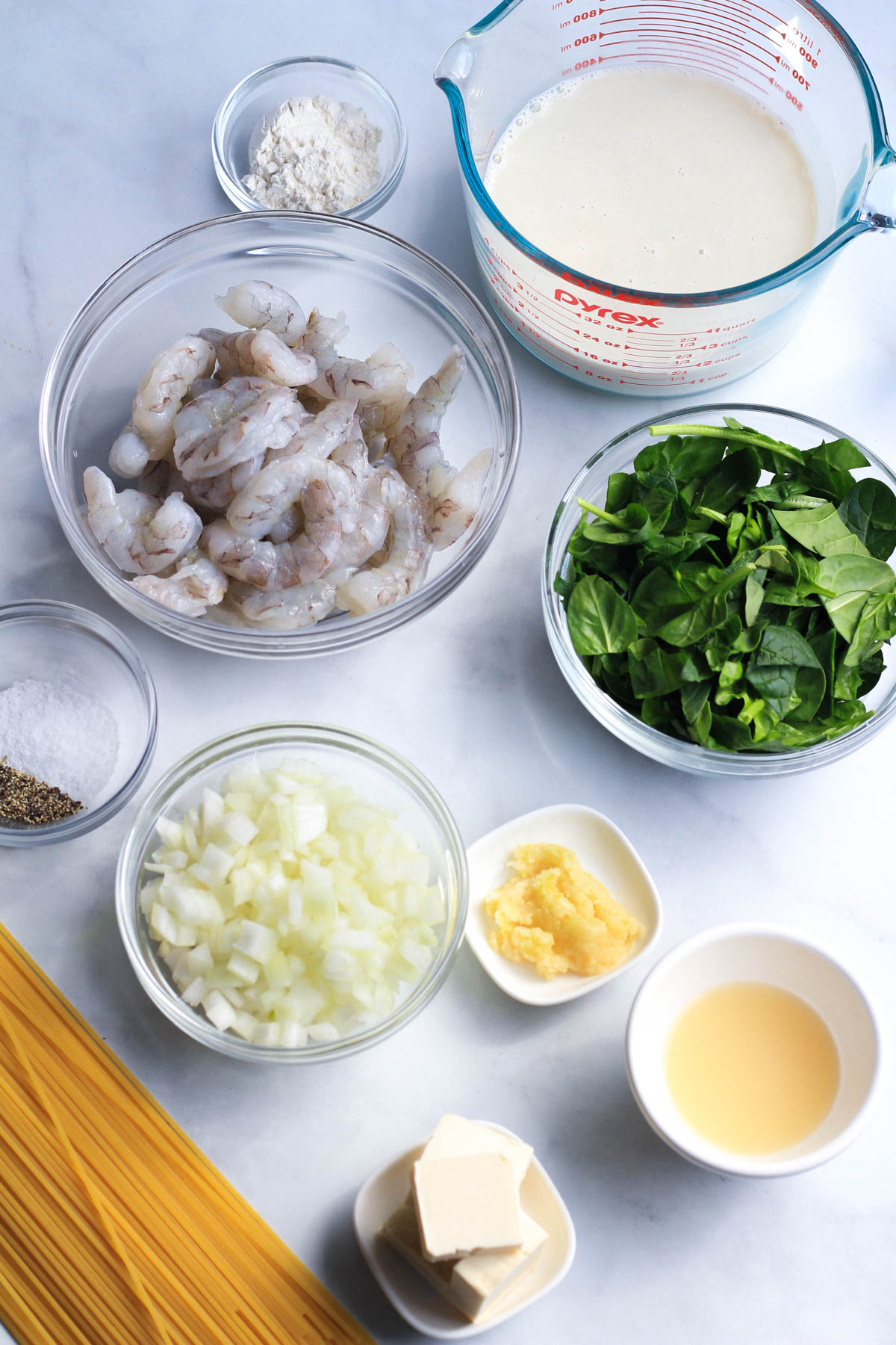 Ingredients for creamy garlic shrimp pasta on a counter.