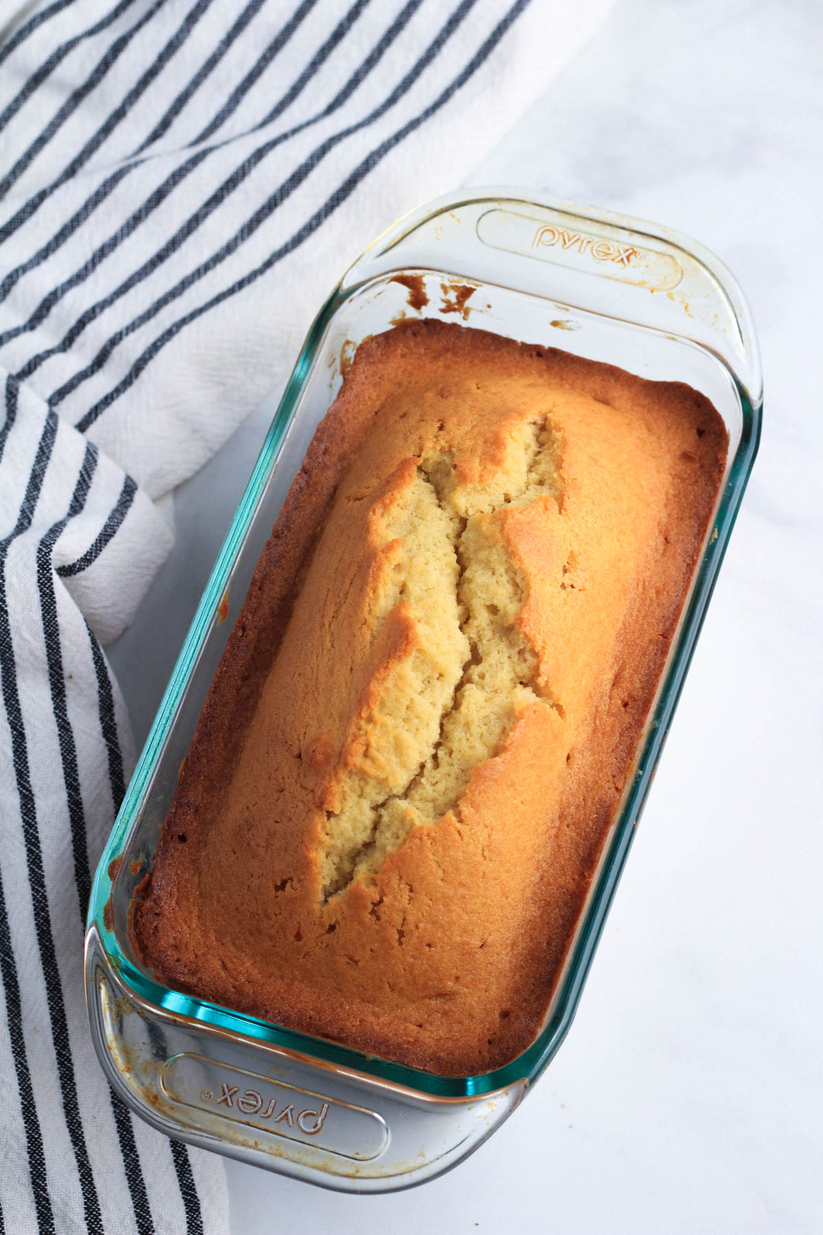 A vanilla pound cake in a glass loaf pan.