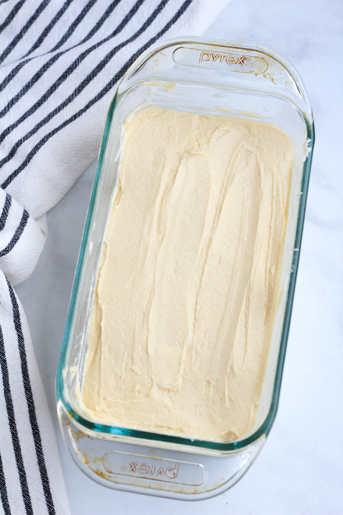 Dairy-Free vanilla pound cake batter in a glass loaf pan before baking.