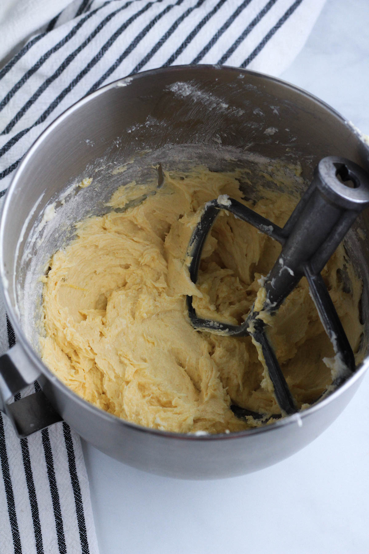 Cake batter in the bowl after adding half of the flour mixture.