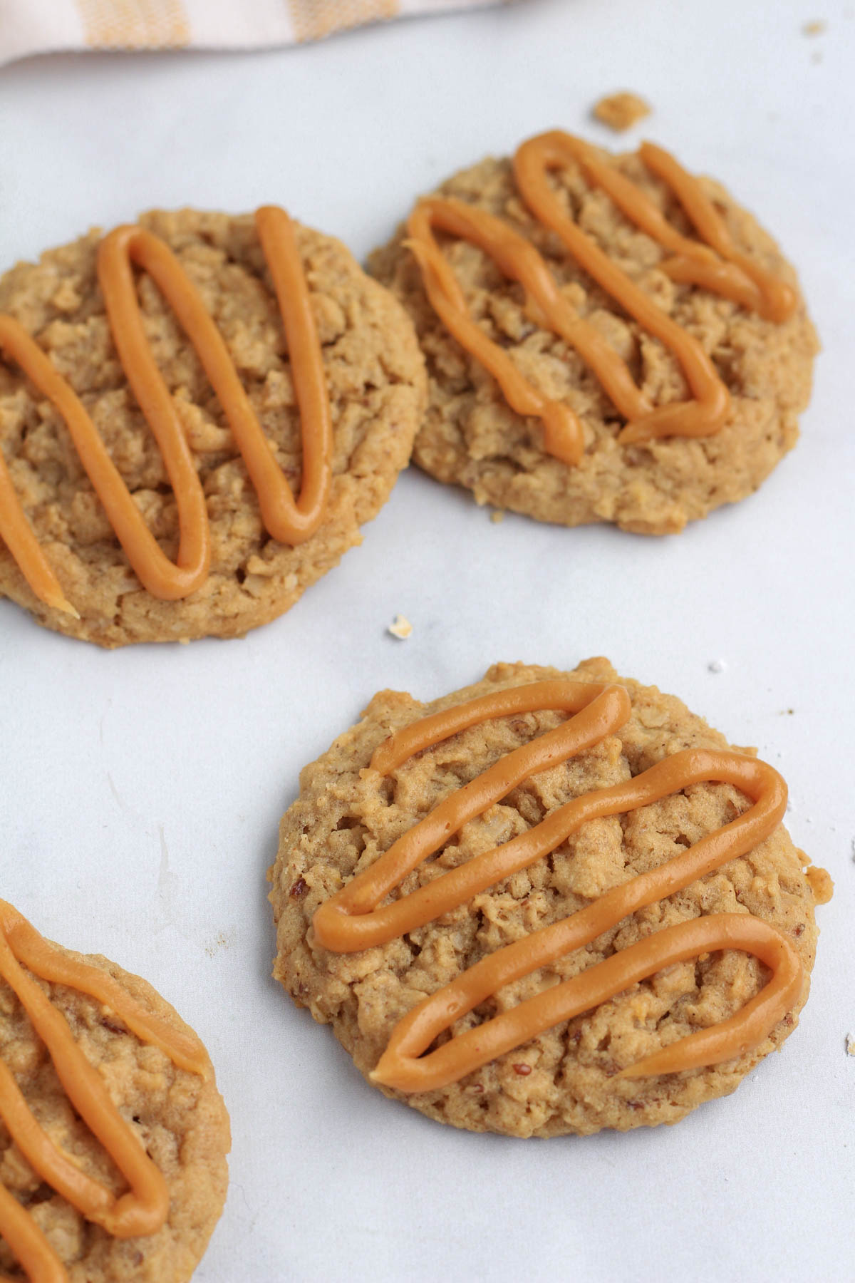 Vegan peanut butter cookies with frosting on a white counter.