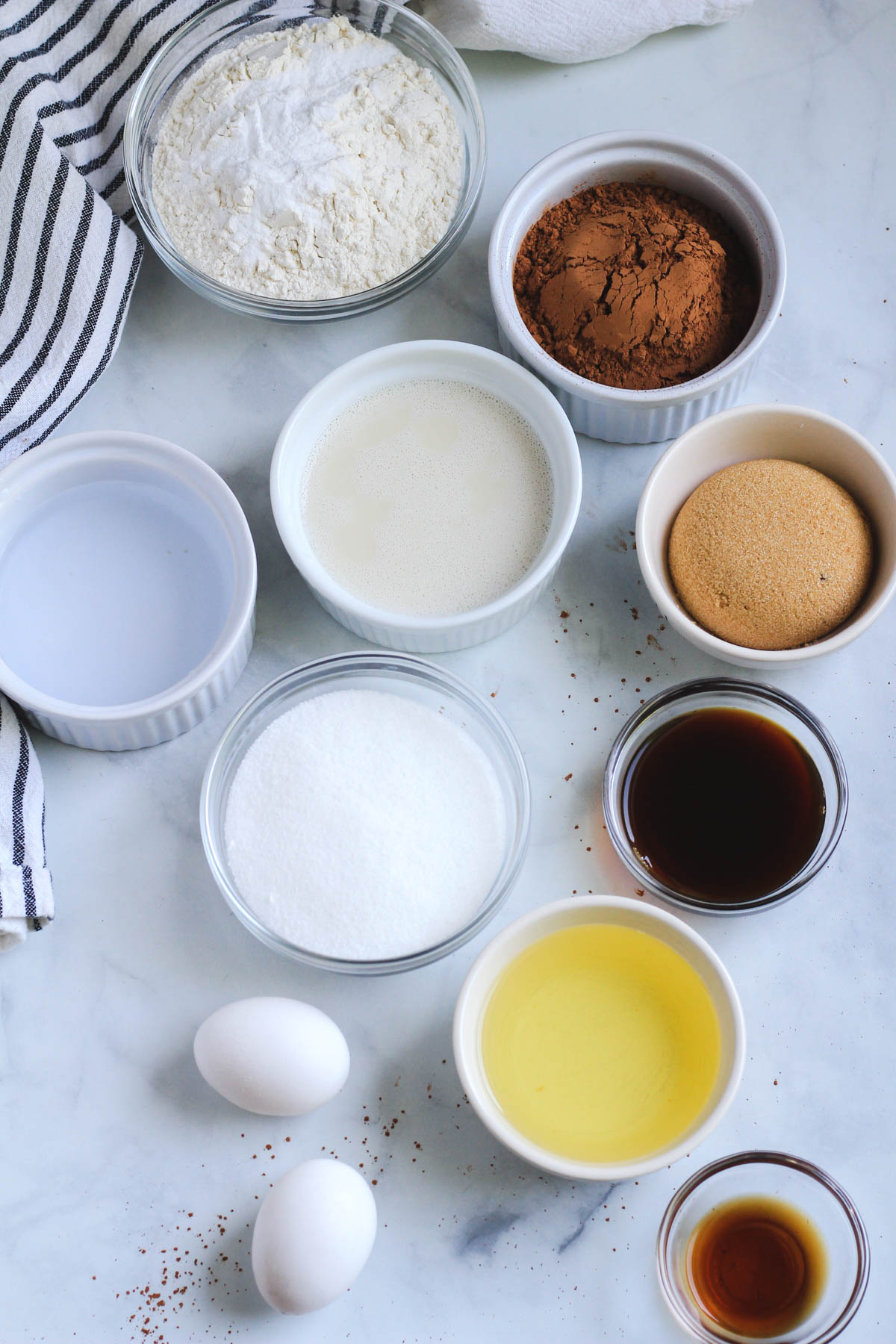 Ingredients for chocolate cake on a white counter.