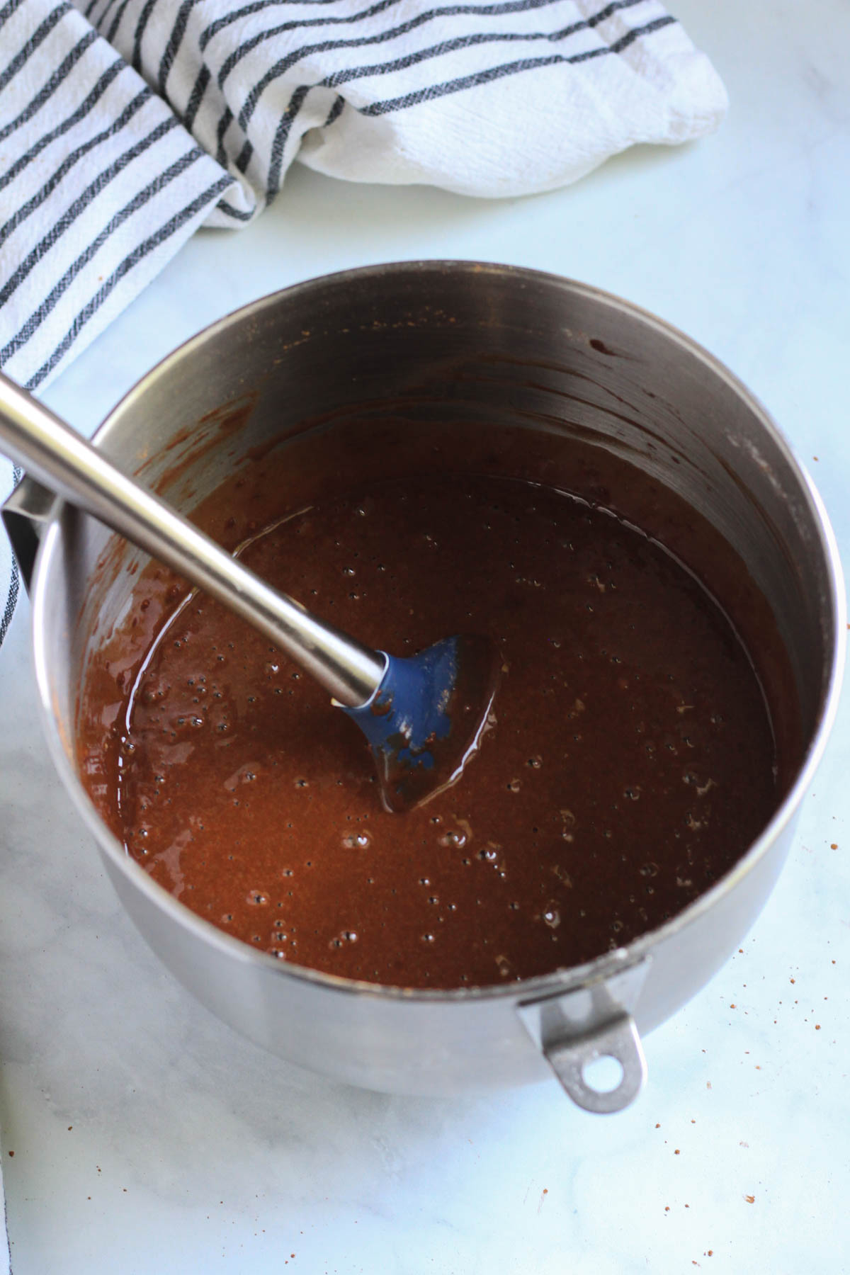 A silver mixing bowl with a rubber spatula after the dry ingredients were folded into the batter.