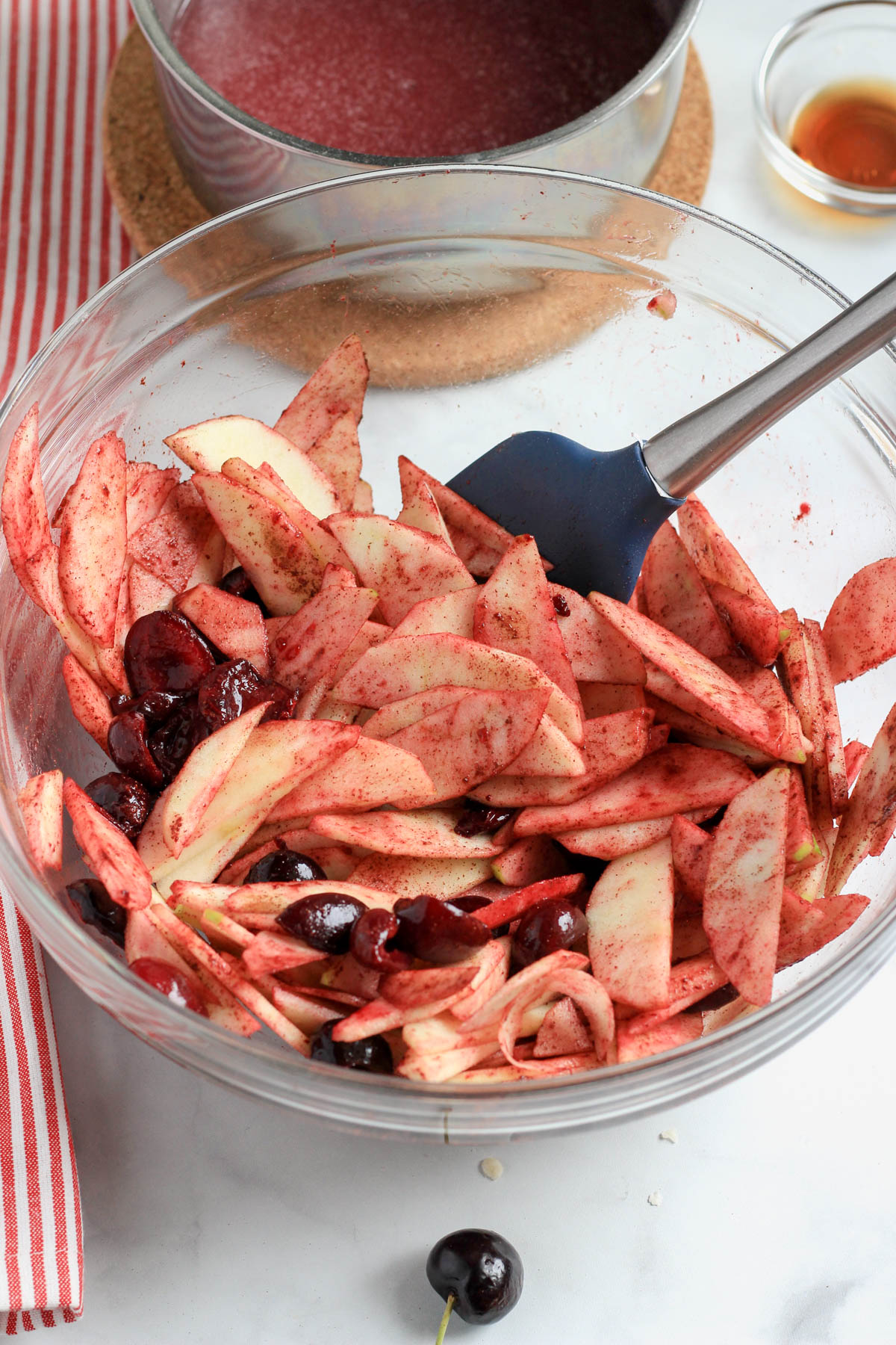 A glass bowl with vegan cherry apple pie filling before the cherry filling is added.
