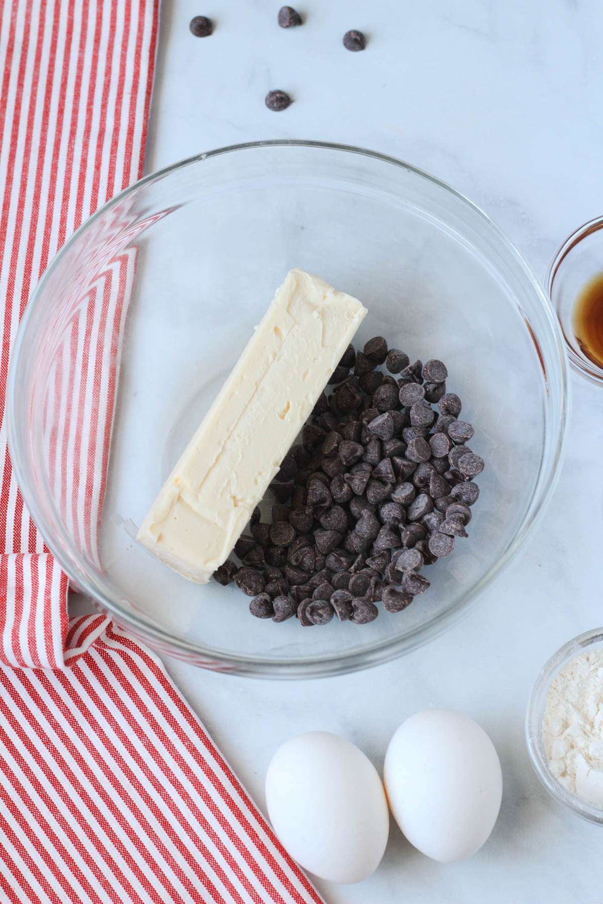 A glass bowl with dairy-free chocolate and vegan butter before melting.