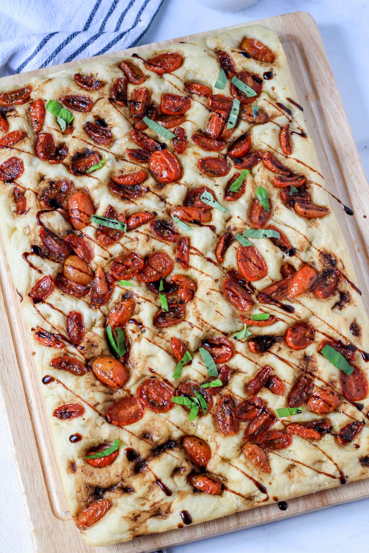 Focaccia with balsamic marinated tomatoes drizzled with balsamic glaze.