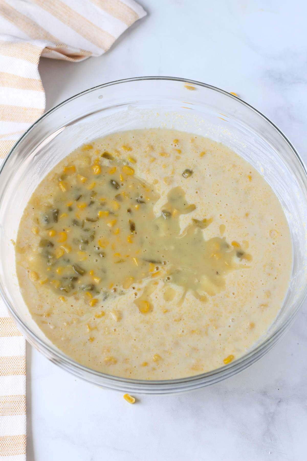 Jalapeño creamed corn added to the glass bowl with corn casserole.