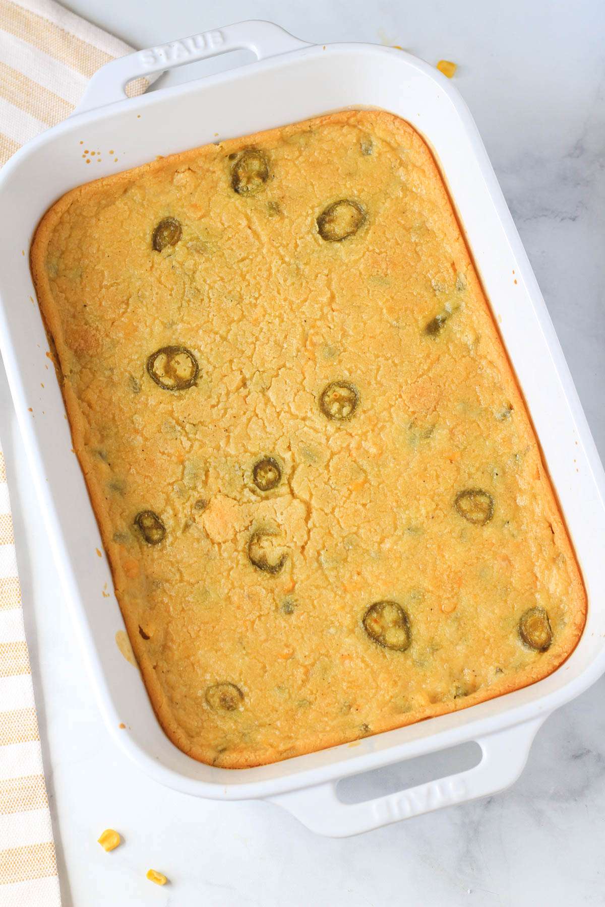 A white baking dish with jalapeño corn casserole after baking.