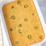 A close up of jalapeño corn casserole in a white baking pan.