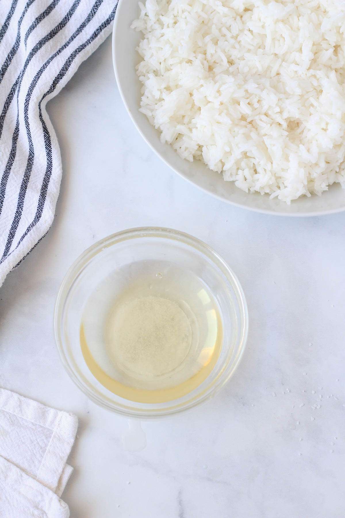 A glass bowl with the rice vinegar mixture mixed together.