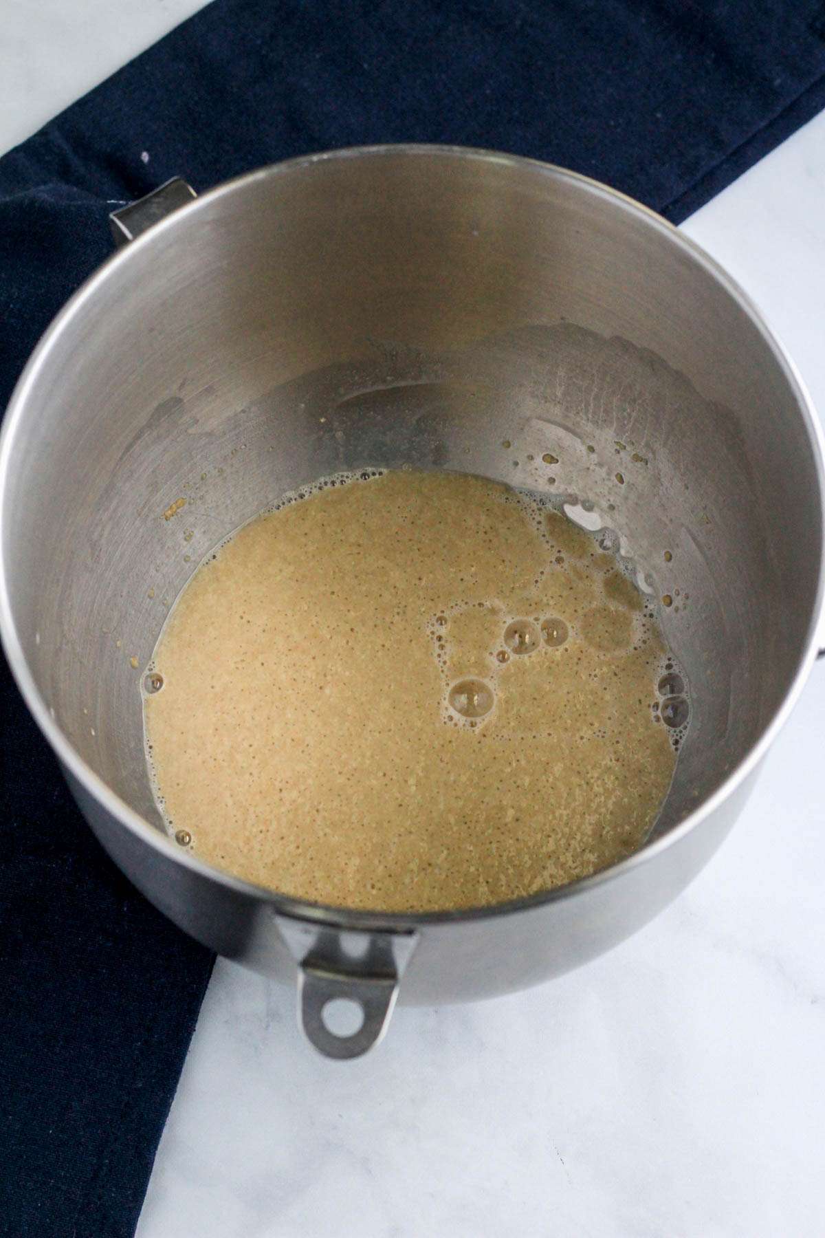 A silver mixing bowl with yeast activating.