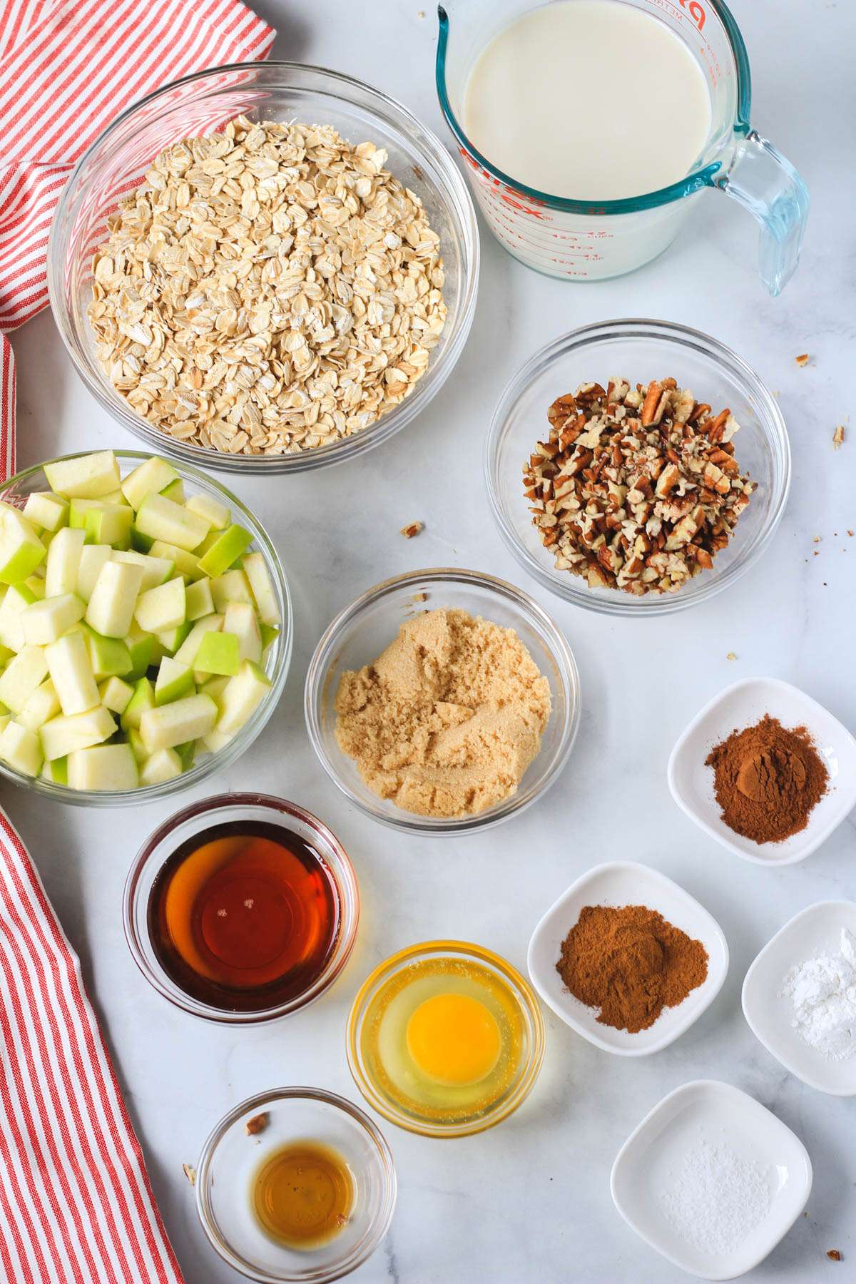 Ingredients for apple pie baked oatmeal on a white counter.