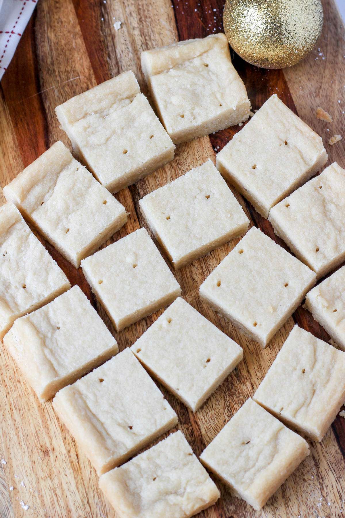 Cut squares of classic vegan shortbread on a wooden counter.