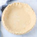 A close up of the crisco pie dough in a pie pan before baking.