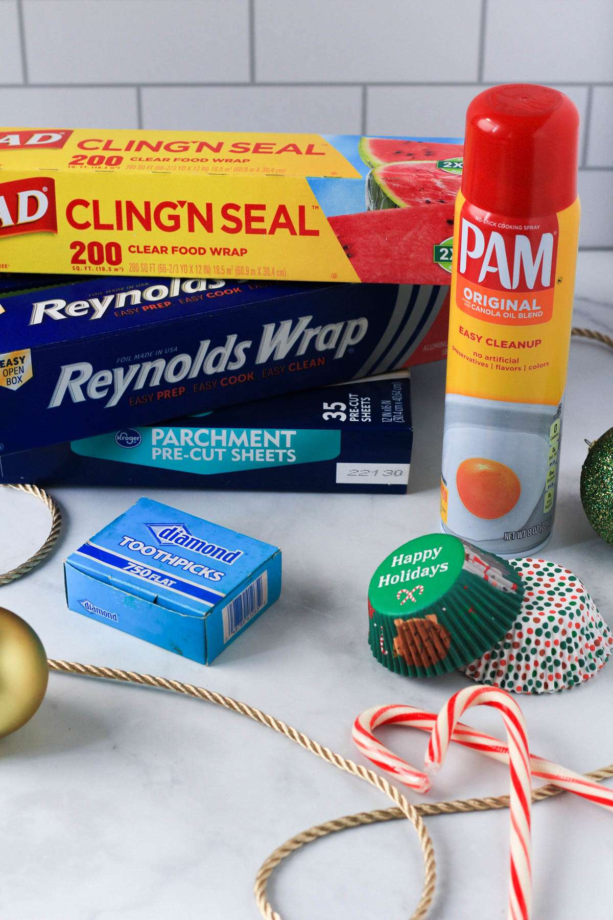 Holiday baking essentials like plastic wrap, parchment paper, toothpicks, and non-stick spray.