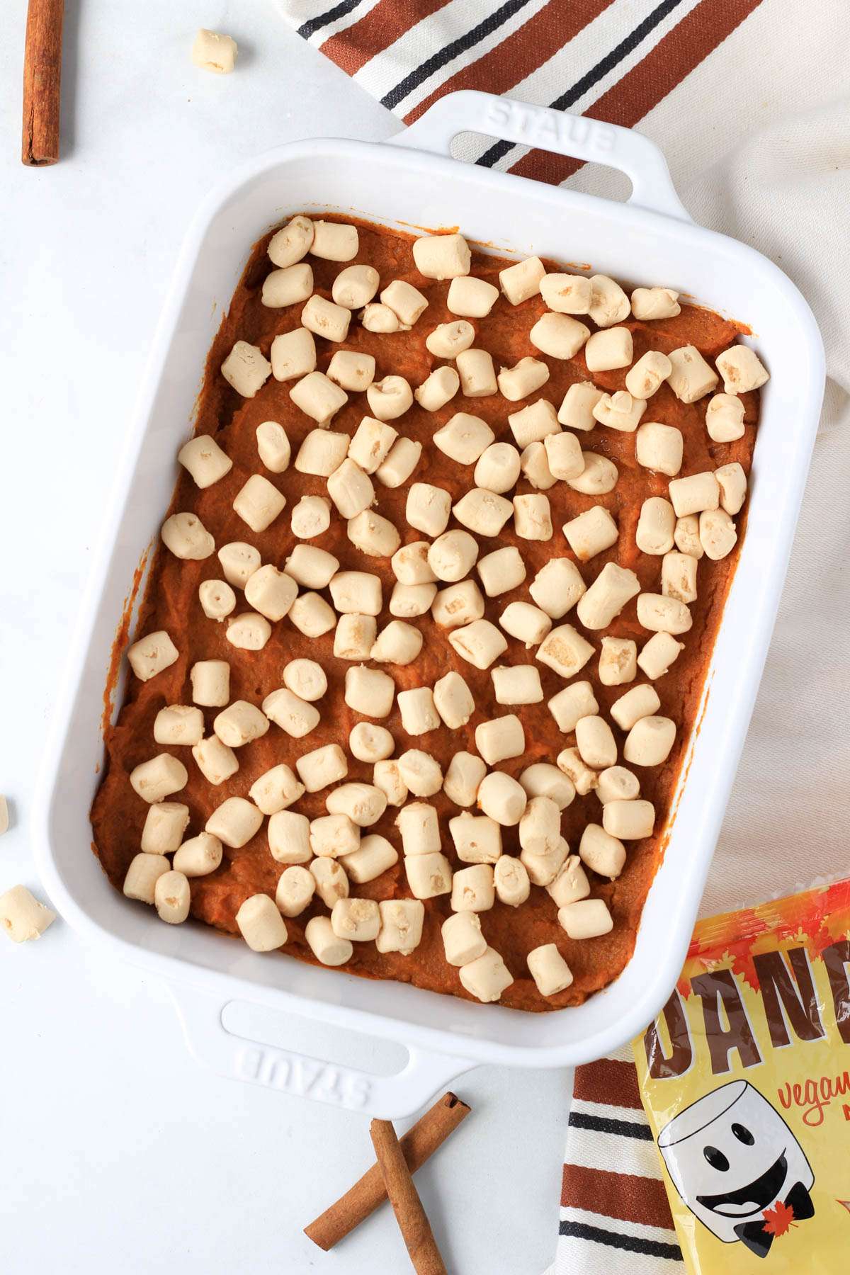 Maple sweet potato casserole in a white baking dish topped with vegan maple-flavored marshmallows.